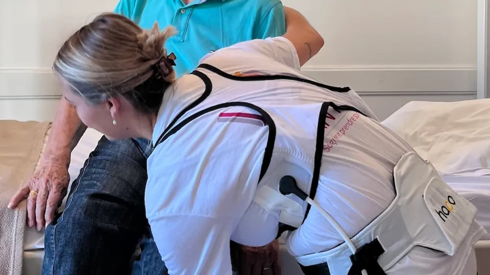 Operatrice sanitaria con esoscheletro HAPO durante l’assistenza a un paziente